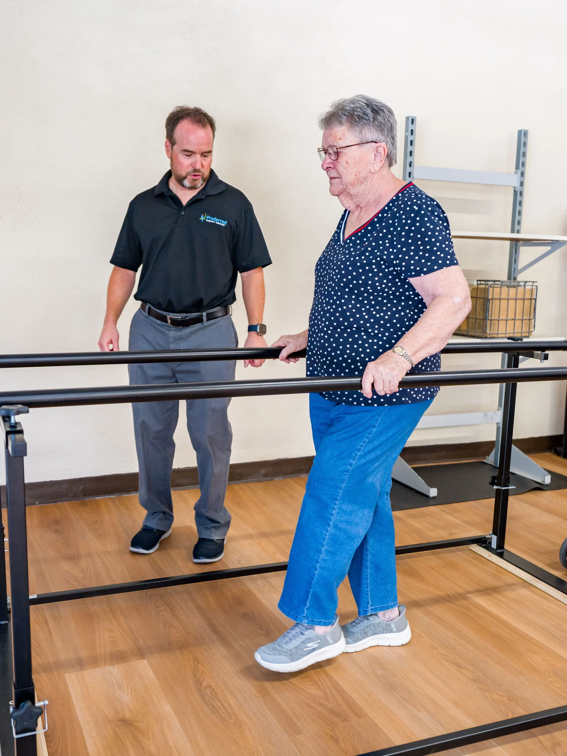 Balance patient with therapist using parallel bars