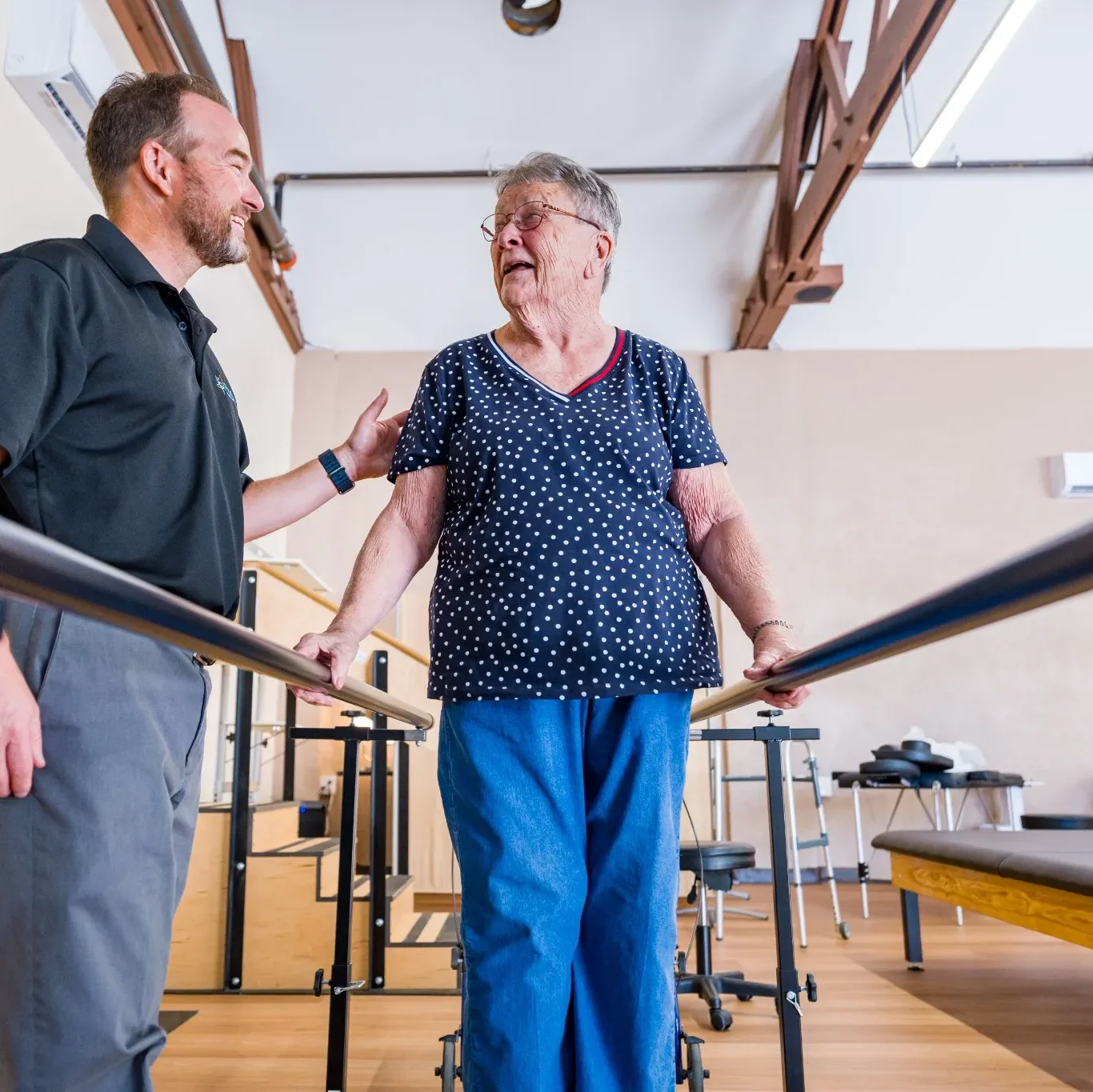 Preferred therapist with patient on parallel bars